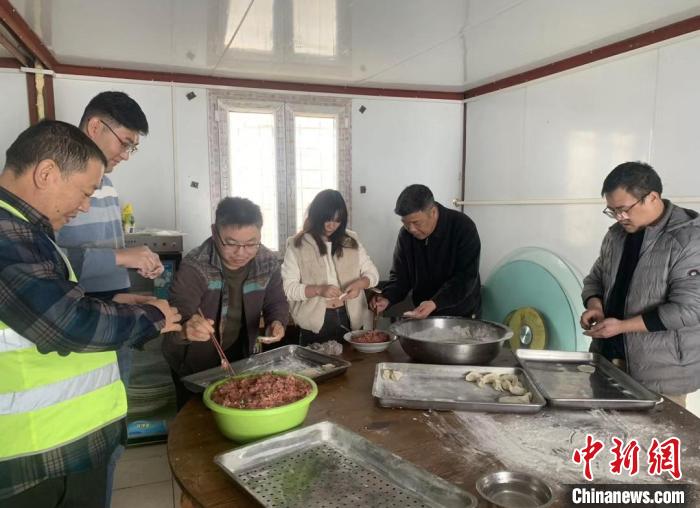 李劲(右二)和阿尔及利亚杜维拉四万座体育场项目员工一起包饺子迎接春节。　沈海军 摄